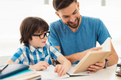 Little Boy in Glasses Doing Homework with Father.